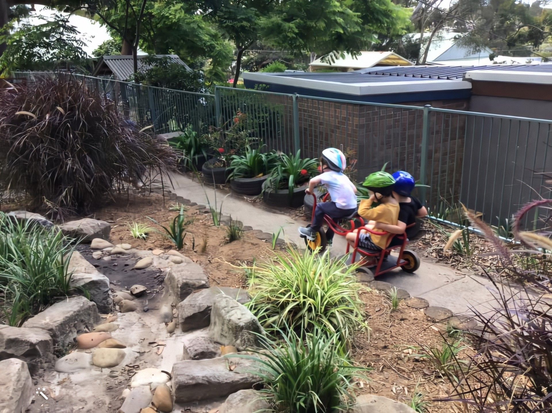 Children riding bikes in the preschool garden